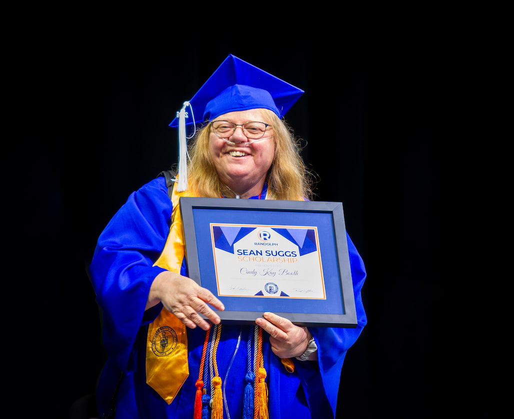 Photo of a graduate holding an award.
