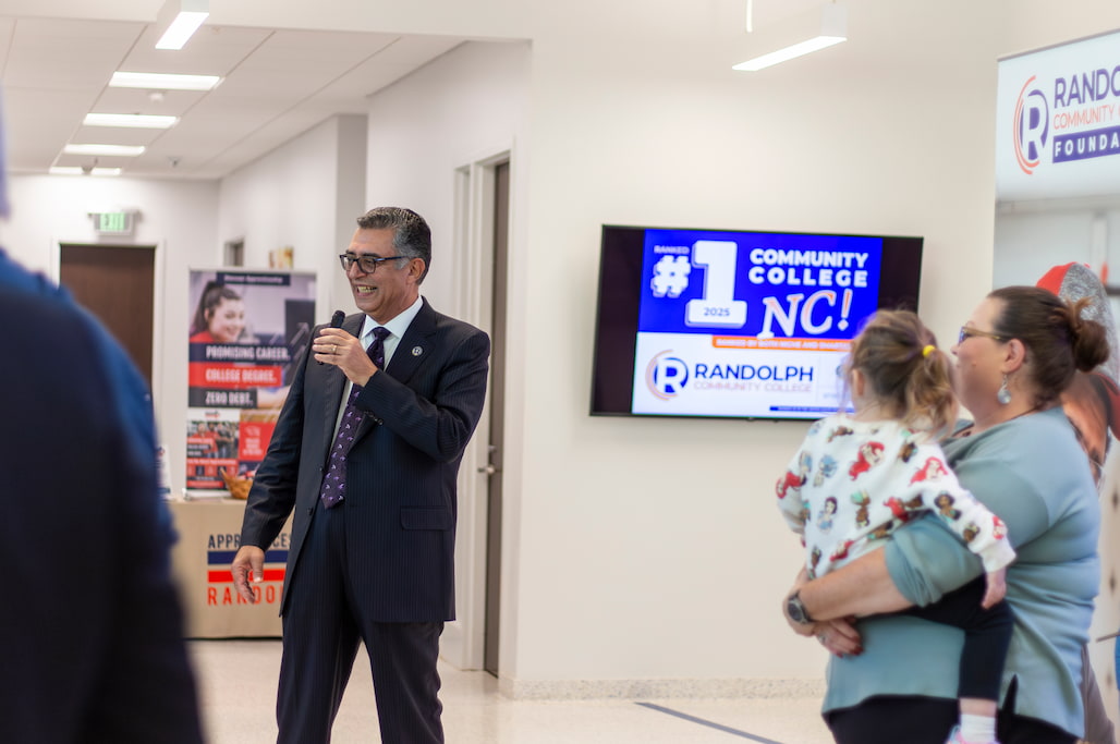 Photo of a person talking to a group of people at Business After Hours in the lobby of Randolph Community College's Allied Health Center.