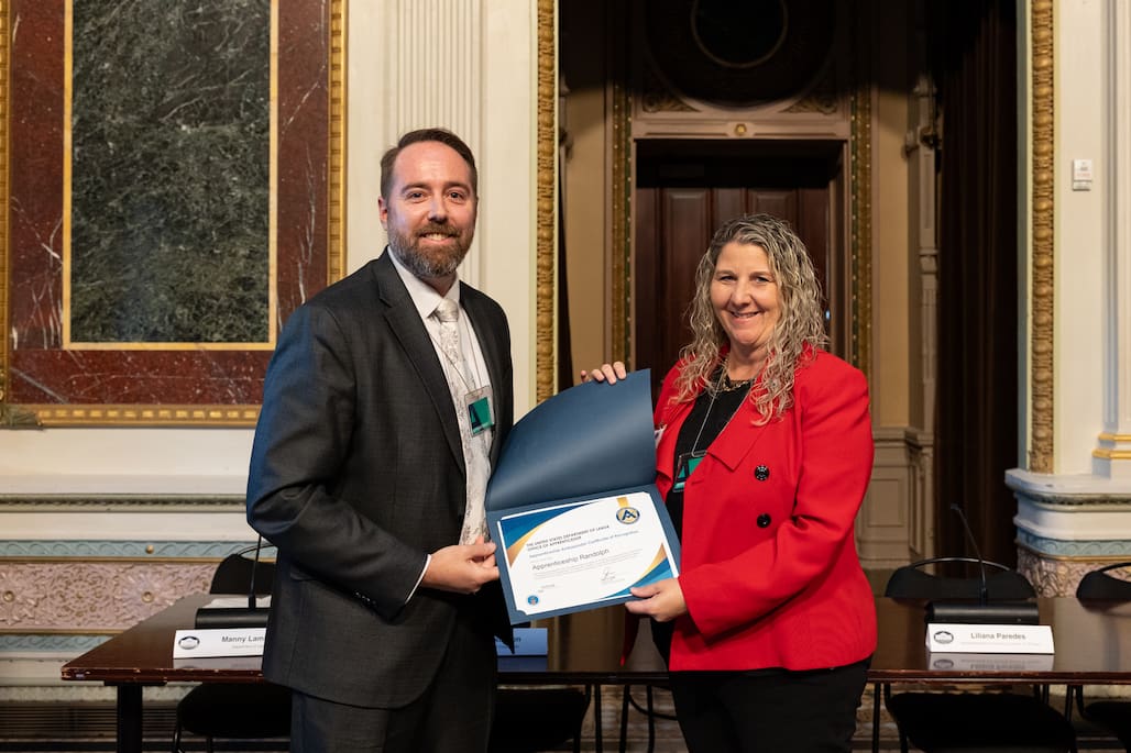 Photo of two people holding a certificate.