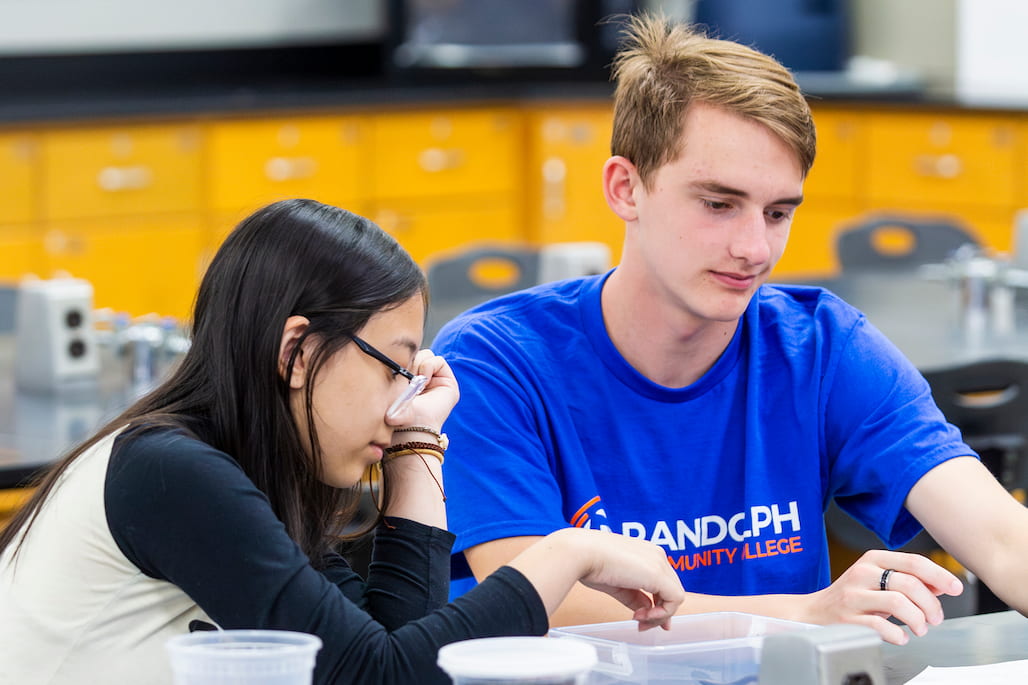 Photo of two students looking at something in a lab.